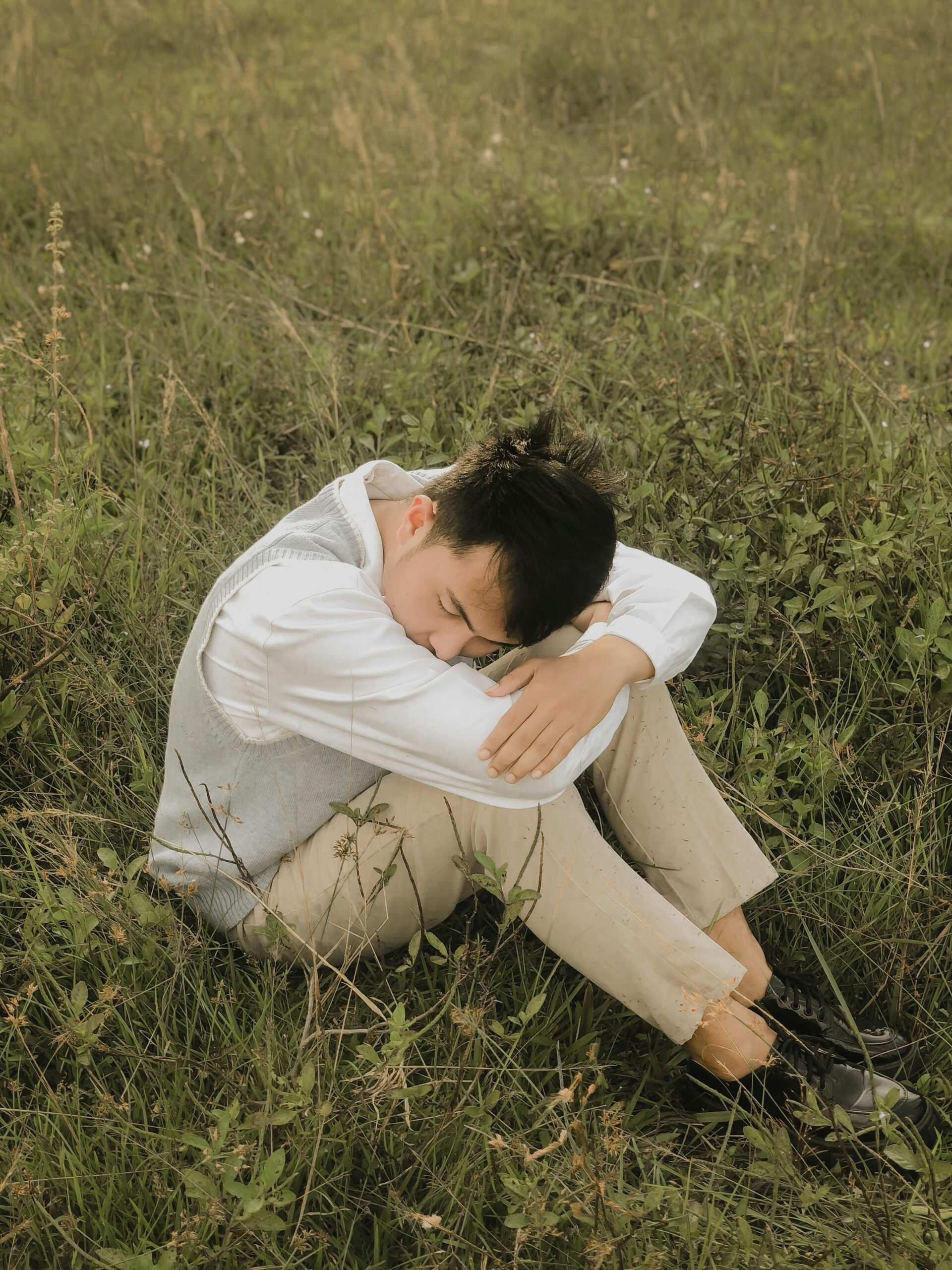 A man sitting in the grass before seeking out anxiety therapy Chicago