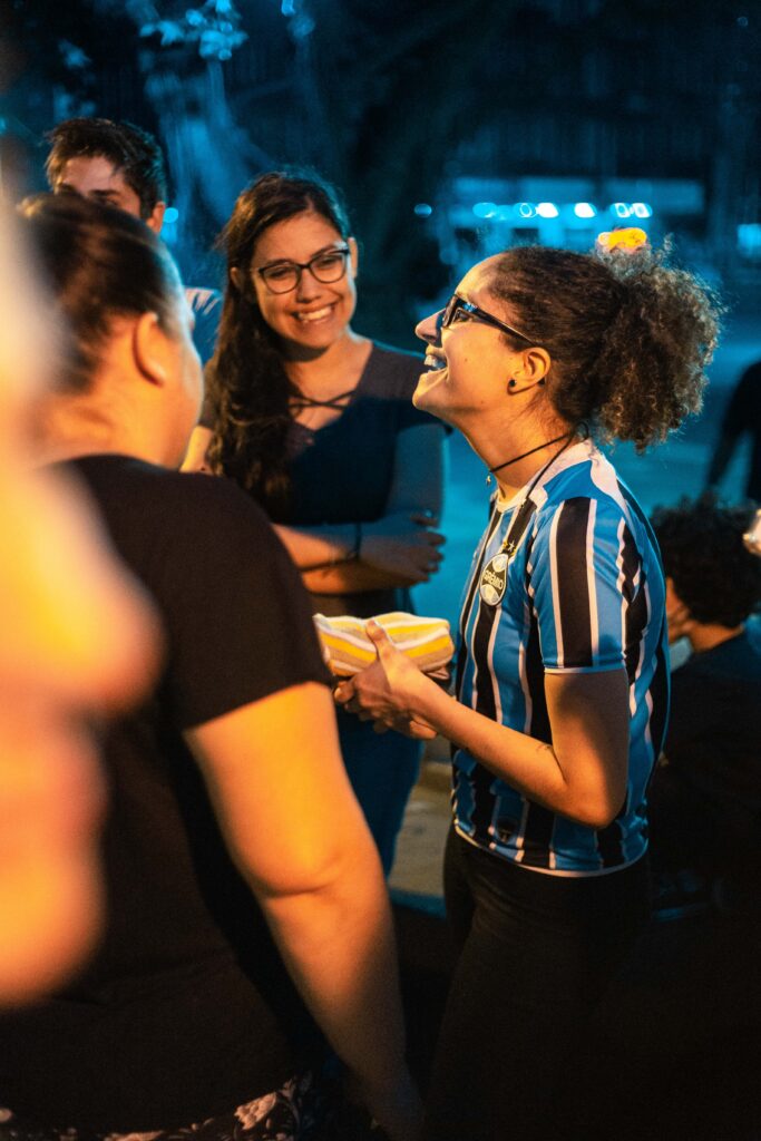 group of Spanish-speaking friends talking and laughing together at night outdoors