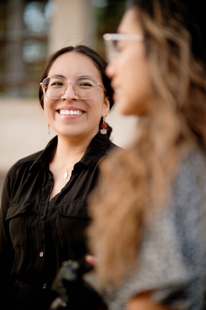 spanish speaking woman smiling at another woman next to her after a bilingual therapy session